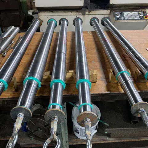 Row of finished, precision-machined rams staged for shipment at Astro Tool & Machine Co.