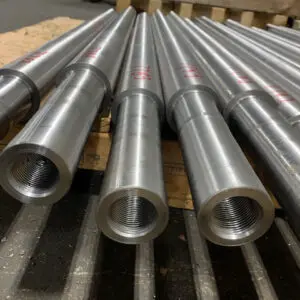 Ram Components Staged for Production — Astro Tool & Machine Co. Batch of precision-machined ram components with threaded bores staged on a pallet at Astro Tool & Machine Co.